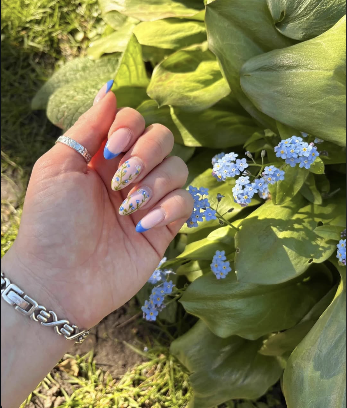 Pale pink nails with blue French tips and forget-me-nots