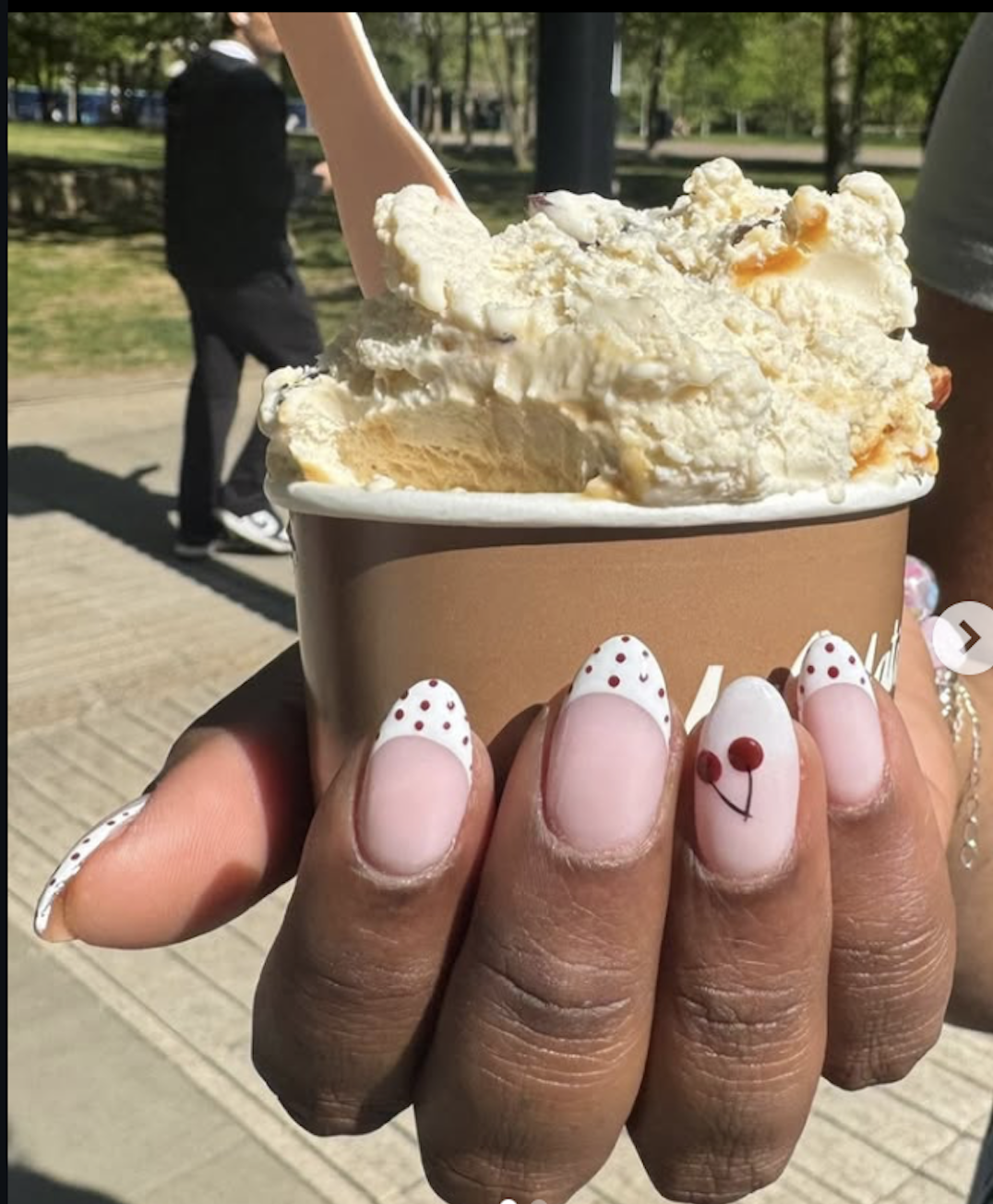 White polka-dot French tips with cherries holding an ice cream cup