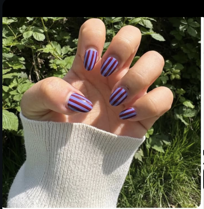 Lilac and burgundy striped oval nails outdoors