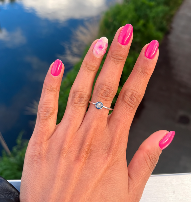 Hot pink almond nails with a white flower accent nail by a lake
